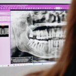 A close-up of a dentist reviewing a dental X-ray image on a computer screen, focusing on oral health analysis.
